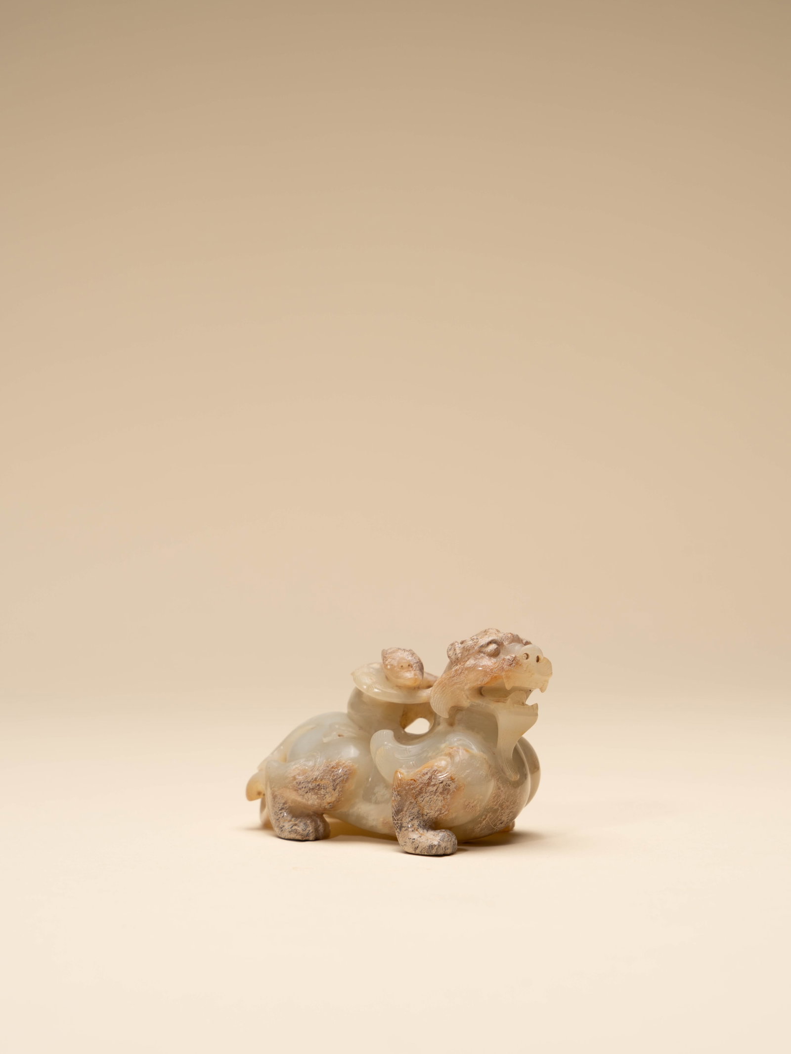 A JADE FIGURE OF A FEATHERED IMMORTAL RIDING A MYTHICAL BEAST: 年代(Age):HAN(206 B.C.-220 A.D.) 。尺寸(Size):8.5 cm Length, 5 cm Height。 來源：台灣私人藏家舊藏&
