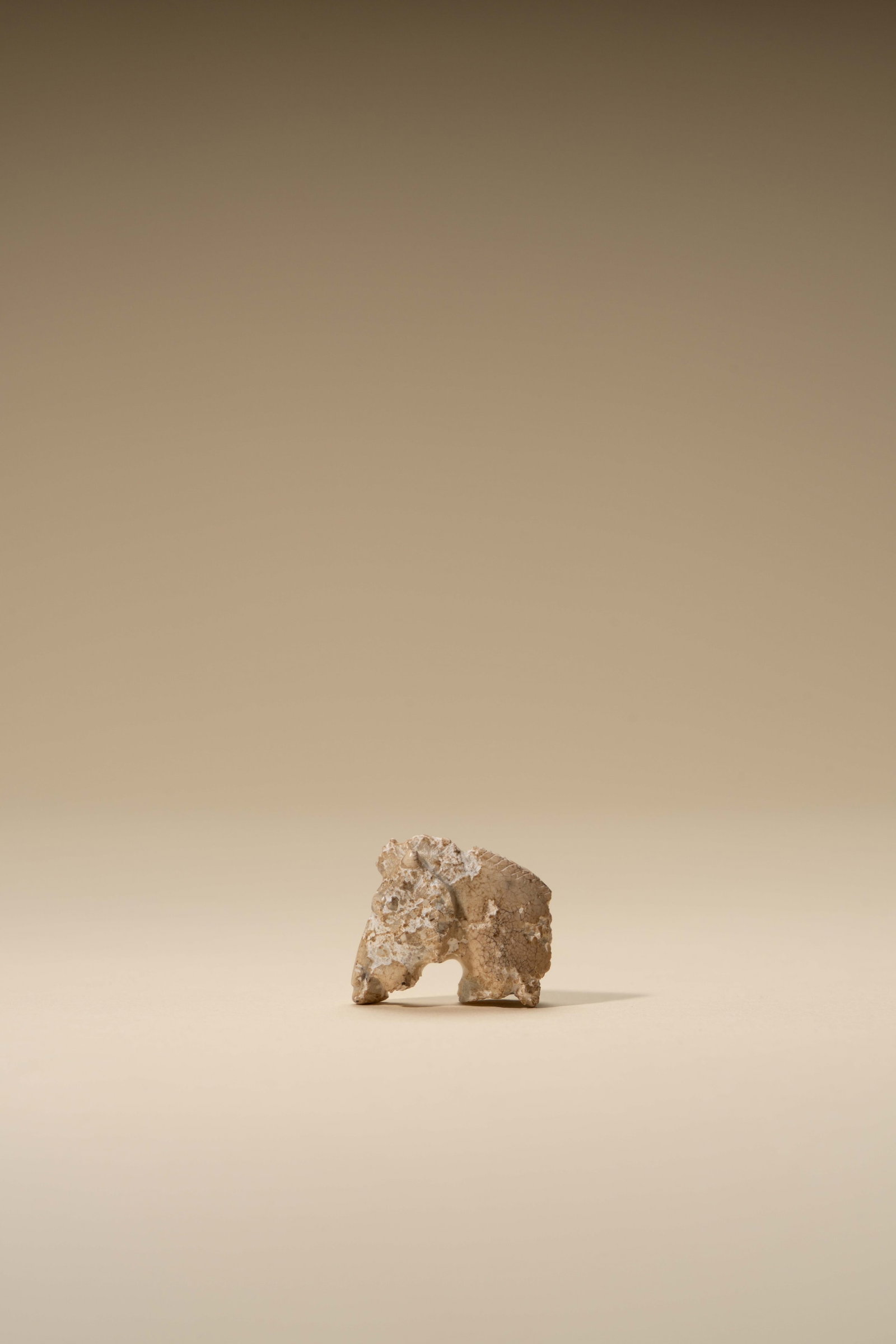A WHITE JADE 'HORSE-HEAD' ORNAMENT: 年代(Age):HAN(206 B.C.-220 A.D.) 。尺寸(Size):2.5 cm Length, 2.8 cm Height。 來源：日本私人收藏。