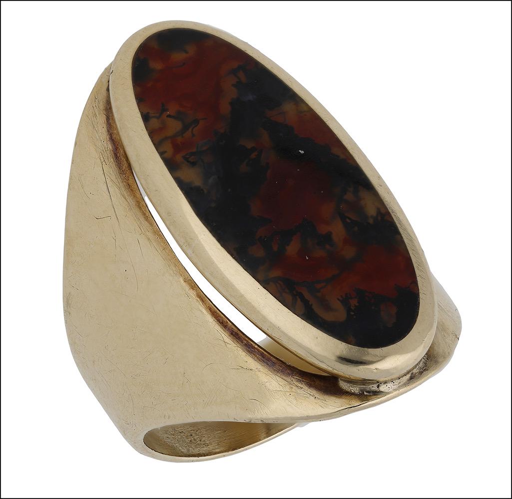 Jewellery: A moss agate ring by David Scott Walker, 1999, the polished oval agate plaque in a rubover setting between broad tapering shoulders, mounted in 9ct gold, makerâ€™s mark, Sheffield hallmark, ring