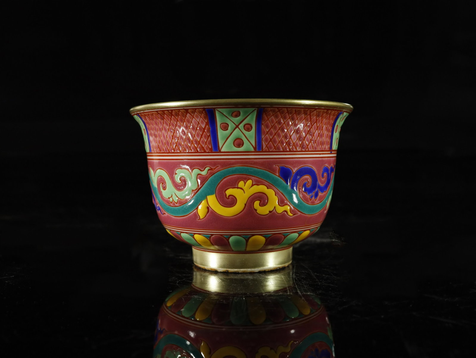 A red-ground wucai painted gold 'flower' bowl: A red-ground wucai painted gold 'flower' bowl Chinese Ming Dynasty Mark of XuanDe Size:10.8cmx7.5cm