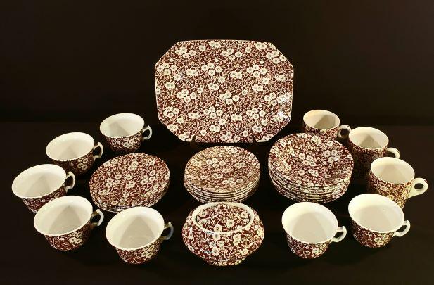 Calico Brown by Crownford China Co.: Calico Brown by Crownford China Co. Staffordshire England. White flowers on brown background disconuieded in the 1960's. In this set: six cups and saucers, plus one extra saucer, five bread and butter