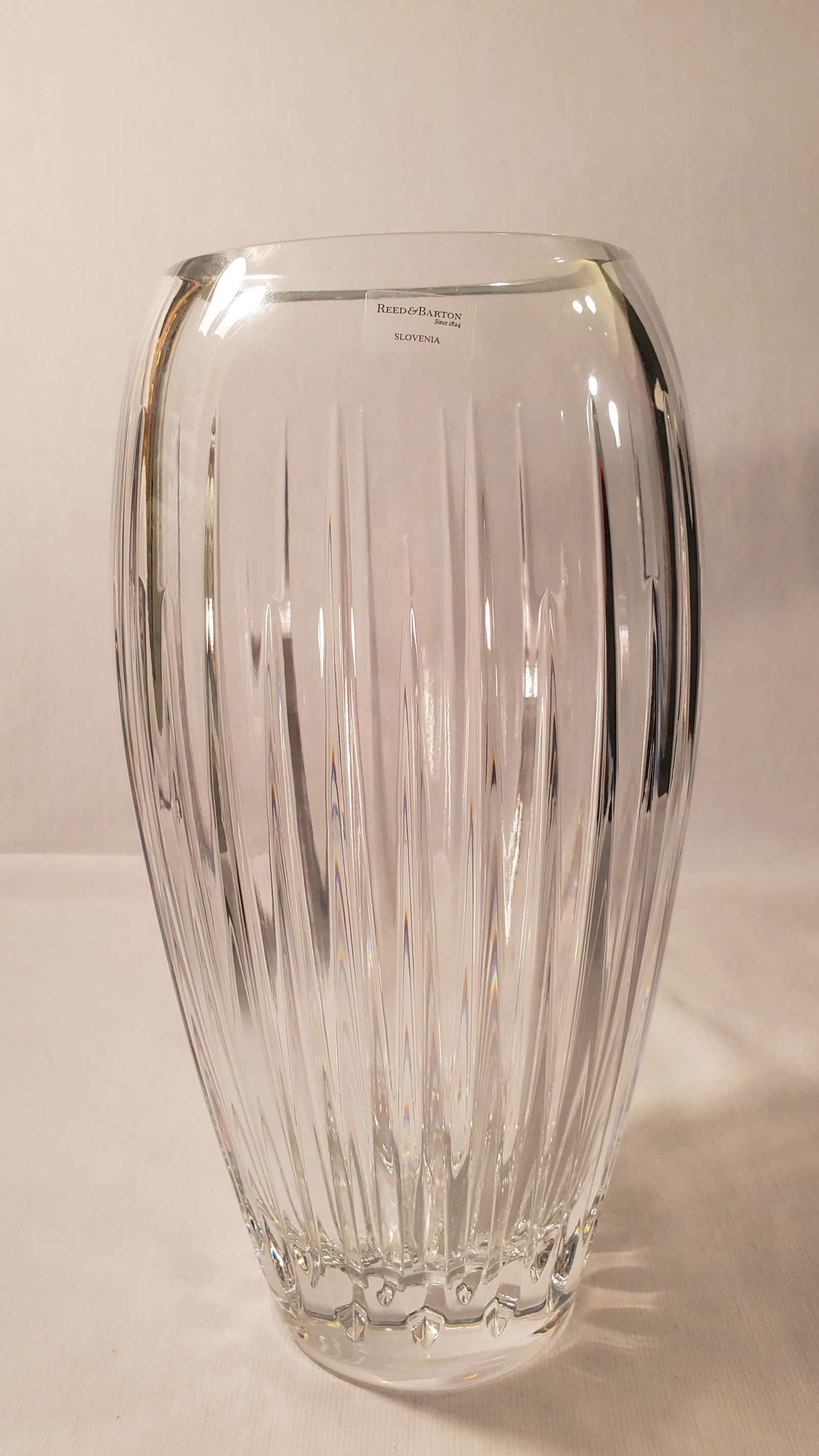 Reed & Barton Soho Crystal 10" Vase: Deep elegant cuts create the stunning SoHo Crystal 10" Vase from Reed & Barton. A perfect design accent, beautifully displaying your favorite flowers, this sophisticated crystal vase adds a rich brill