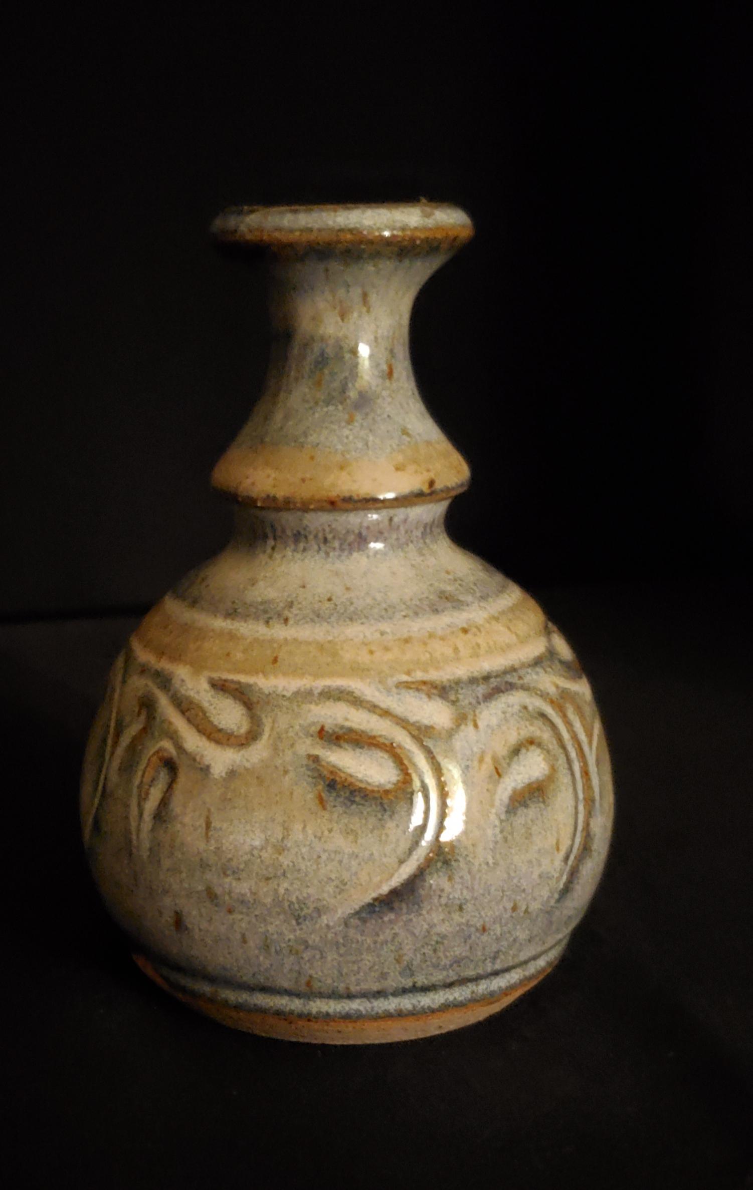 Sandy Hilton Pottery Vase: 5" tall with a 2"base and 1" opening; This handmade pottery is one of many pieces that she has made. The earth tone colors pop right out of the vase. Signed on the bottom.