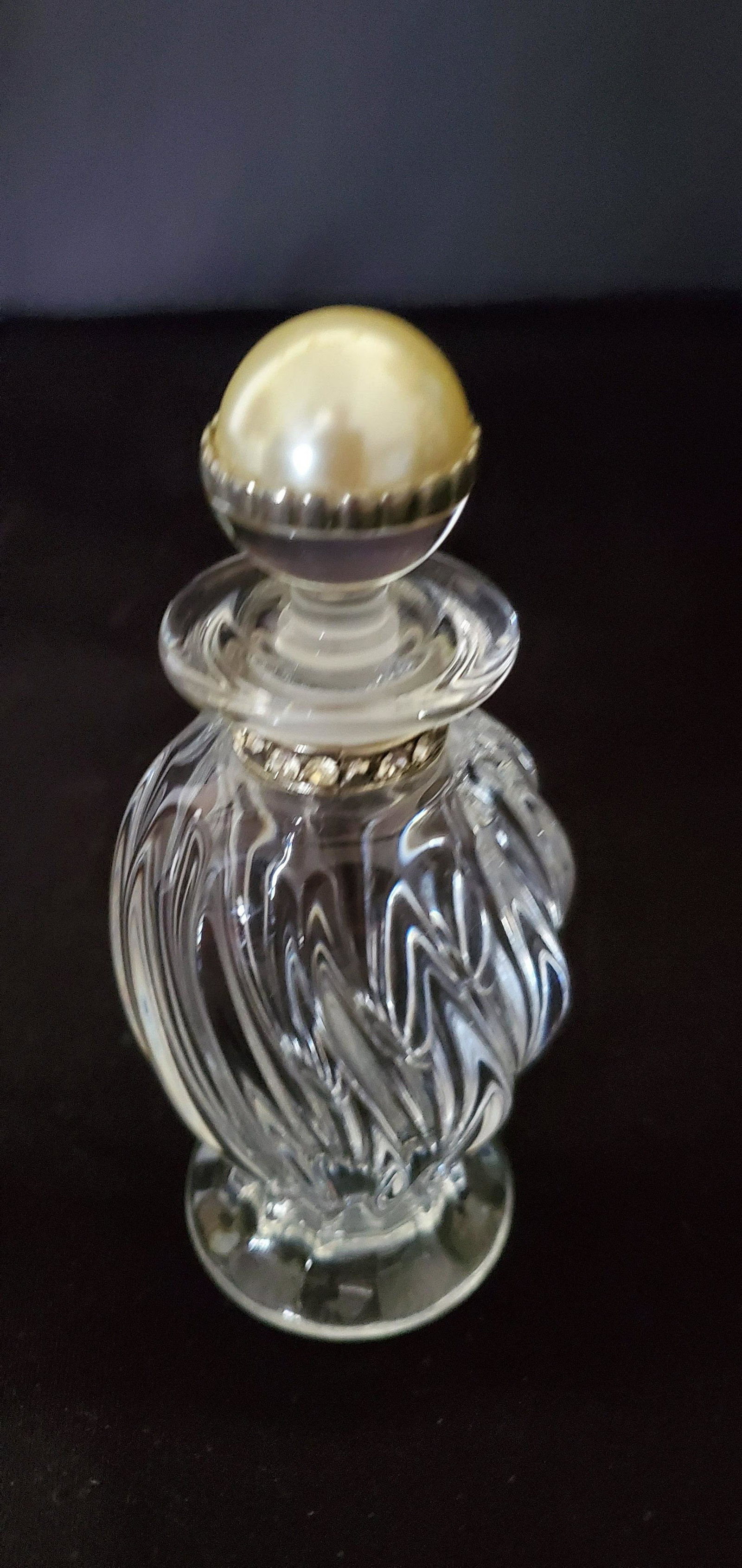 Vintage Twisted Clear Glass Purfume Bottle: Vintage Twisted Clear Glass Purfume Bottle with Rhinstones on the neck of the bottle and half clear glass and half pearl top stopper. This bottle is labeled Made in Czech Republic. 5" tall x 2" diamet