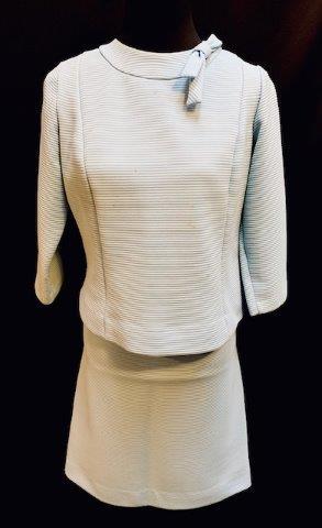 Pale Blue Ladies Skirt Suit: Beautiful light blue skirt suit is made of a heavier ribbed fabric with bow detail on the collar and three-quarter length sleeve. Zips up the back. Slight spotting and make up residue should come off 