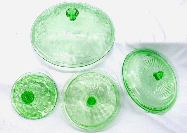 Depression Glass Replacement Lid Group Lot: Four various green depression glass replacement lids. Largest poinsettia pattern, cubist, swirl, and story.