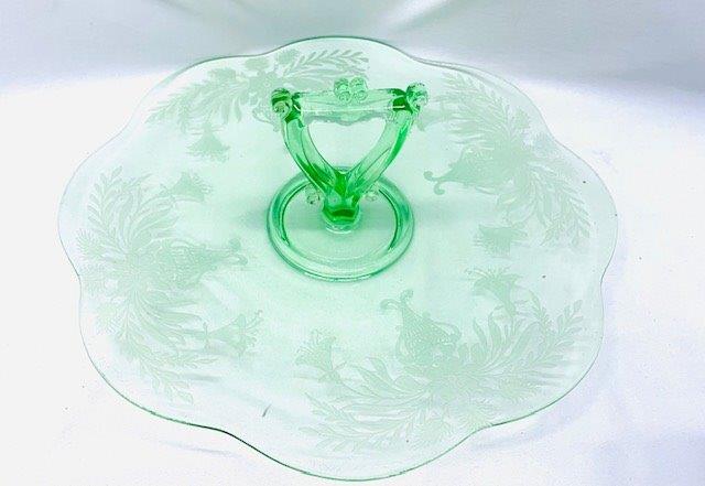 Stunning Green Depression Glass Center Handle Serving: This vintage green depression glass center-handled serving dish is simply gorgeous, from its beautiful scrolling floral etched design to the detailed scroll in the center handle. Measures 12 inches in
