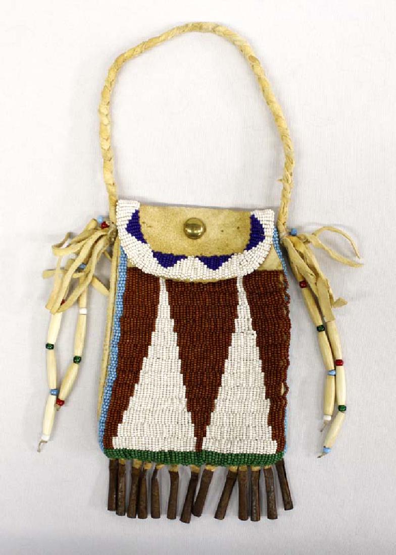Antique Sioux Beaded Strike A Lite Bag: Antique Native American Sioux Beaded Strike A Lite Bag, measures 4.5'' x 7.5'', embellished with bone hare pipe beads, tin jingles, cloth lined, braided leather handle and leather fringe, brass brad o