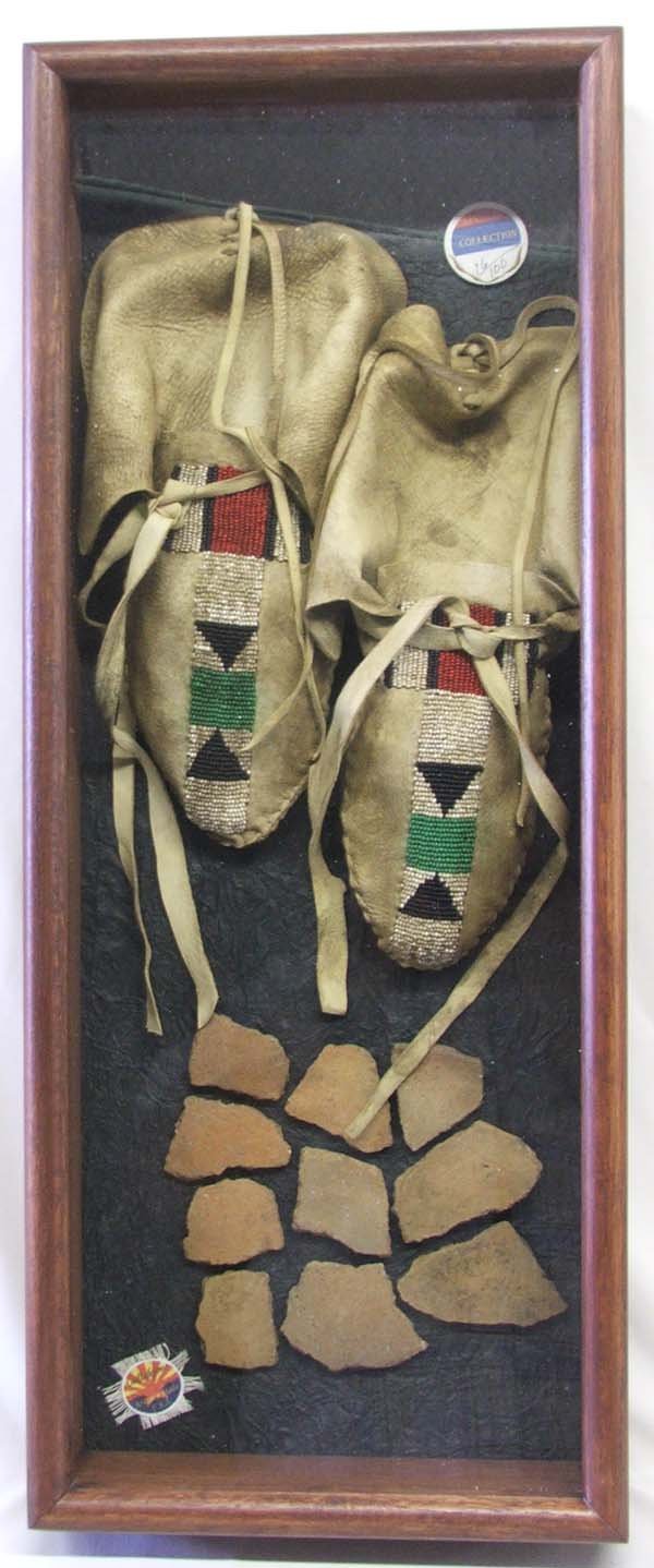 Replica Moccasins and Pottery Sherds in Glass Box: Replica Moccasins and Pottery Sherds in Glass Shadow Box (With Wooden Frame), 23''x8.5''. SHI $40.