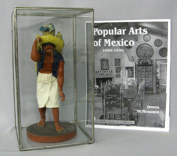 Mexican Beeswax Carbonero Sculpture 13''H: Wax Figure Coal Vender(Carbonero)in Glass Case 13''High x 7''Square. Includes history of beeswax sculpture. Left thumb is broken off and arm is repaired. Possibly sculpted by Andres Garcia. SHI $40.