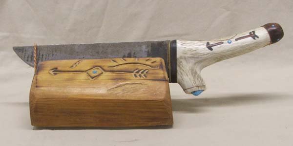 Large Hand Carved Bone Knife: Large Hand Carved Bone Knife, measures approx. 15 1/2'' end to end, blade measures approx. 9'' x 2''Wide. Mounted in carved wooden holder. SHI $20.