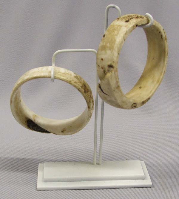 Pair Early 1900s Samoan Shell Bracelets: Pair Early 1900s Samoan Shell Bracelets. Two Polynesian handmade and polished shell bracelets from Samoa. largest measures approx. 2.75'' diameter and 0.75'' wide. Comes with a custom metal stand. SHI