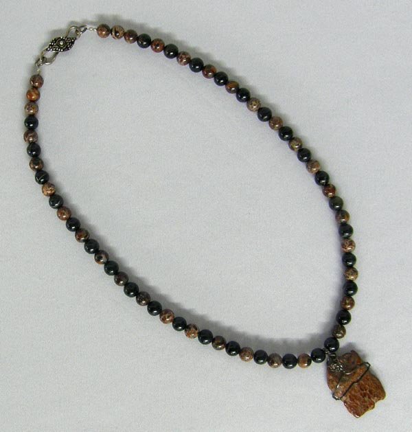 Dinosaur Bone Pendant Necklace By Terry Shafer: Dinosaur Bone Pendant Jasper Bead Necklace By Terry Shafer, Silver City, New Mexico artist. Beads are made of Dinosaur bone and Tiger-eye. Measures approx. 22", pendant measures approx. 1 1/2" x 1". S