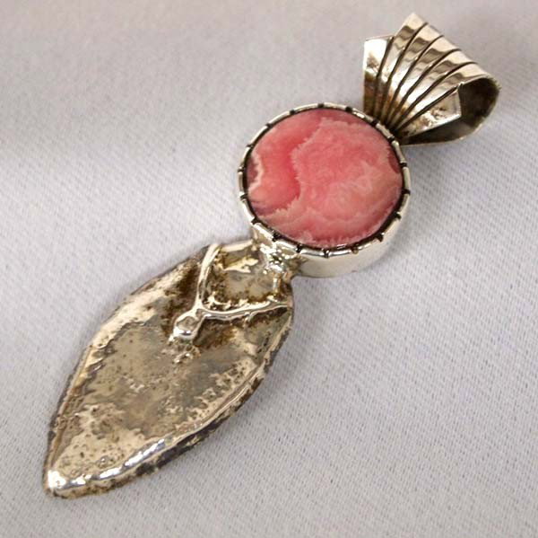 Navajo Silver Rhodochrosite Pendant by Gibson: Navajo Sterling Silver Rhodochrosite on the front of the Pendant and inlay turquoise on the back of the pendant by H M Gibson. Measures approx. 2.5 x .5''W. SHI $15