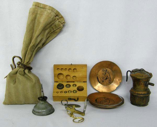 Collection of Western Mining Paraphernalia: Collection of Western Mining Paraphernalia. Includes a brass scale weights (some missing), poke bag, mini copper mining pans, mining lamp and more. Lamp measures approx. 3.5''Hx3''W. Buyers Pay Actual