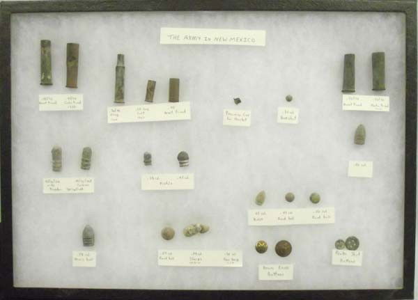 New Mexico Army Artifacts: New Mexico Army Artifacts in large Riker Box Display, items include: Brass Eagle Buttons, Pewter Shirt Buttons, Percussion Cap for Musket, .69 Round Ball, various casings, and bullets, longest bullet