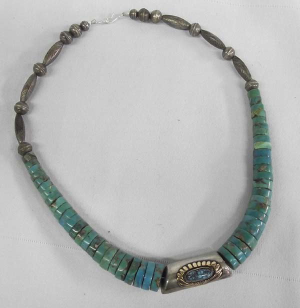 Navajo Turquoise Silver Necklace: Native American Pueblo Turquoise Silver Necklace. Graduated size turquoise Heishi with silver center and silver hollow balls and cones on tips. Measures 18'' end to end. Center silver bead is 5/8'' di