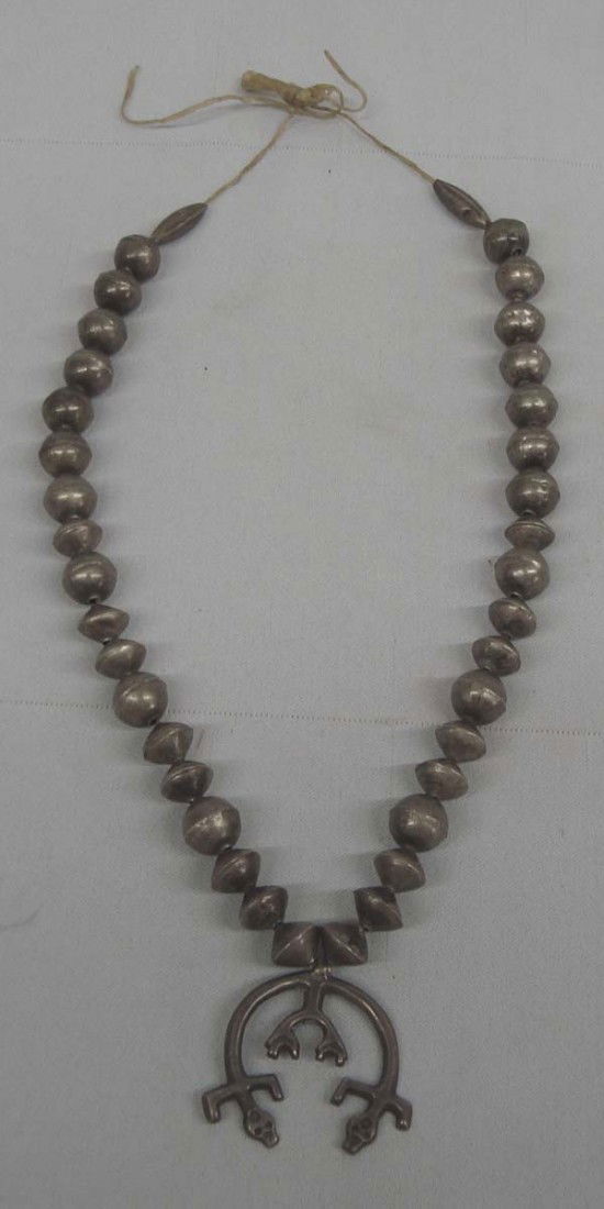 Antique Navajo Naja Sterling Silver Necklace: Antique Native American Navajo Sterling Silver Naja Necklace, strung on sinew. Measures approx. 20'', Naja measures approx. 1 1/3''H x 1 1/2''W. Buyers Pay Actual Shipping and Handling Charges(see ter