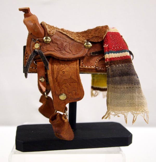 Hand Tooled Miniature Western Saddle on Stand: Hand Tooled Miniature Western Saddle on Stand. Has small serape draped over back of saddle. Measures 5.5''x3''x5'' on the stand. Buyers pay actual shipping and handling charges (see terms and conditio