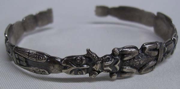 Northwest Coast Totem Sterling Silver Bracelet: Great older piece of jewelry, measures inside (includes opening) 8.5 inches (large wrist), width is little under .50 inch. Marked sterling, with Eskimo totem poles that circle the bracelet. Buyers Pay