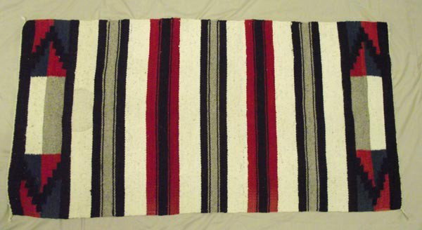 1950's Mexican Rug: 1950's Mexican Rug. Measures 60'' x 30''. Colors are black, red, blue, white and light olive. There is a circular stain measuring 7'' across on one side only. Buyers Pay Actual Shipping and Handling C