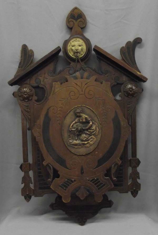Antique Eastlake Victorian Wall Magazine Holder: Eastlake Victorian Wall Magazine Holder. Ornate magazine holder with a large repousse medallion in the center. Lion head at the top with chains which hold the rack open. Measures 30'' x 20''. There ap