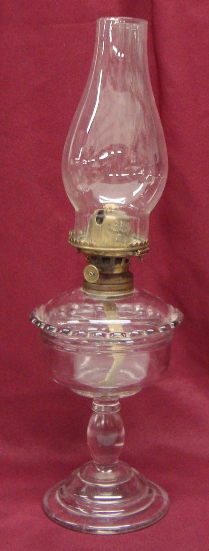 Antique Sun-purpled Glass Oil Lamp: Antique Sun-purpled Glass Oil Lamp. Brass burner marked ''1886 Patent Dec. 10.67'' on wick turner. Chimney has been replaced. 17''H x 5.5'' Diameter. Clean with one tiny glass chip on base. Buyers Pay