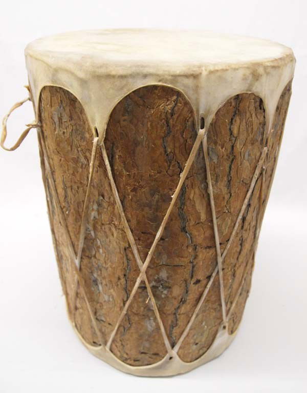 Native American Pueblo Large Drum: ETHNICITY: Native American DESCRIPTION: Large drum with bark still on log. Top and bottom are cow hide. Laced with rawhide and has rawhide handle. SIZE: Measures 18''Hx12''W. Buyer pays actual shippin