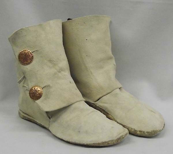 Pair Early Navajo Ladies Suede Mocassins: PUEBLO: ETHNICITY: Native American DESCRIPTION: Light tan suede deer mocassin boots with double concho button closures. Ankle height. Soles are hand stiched rawhide with plenty of life left. SIZE: Sol