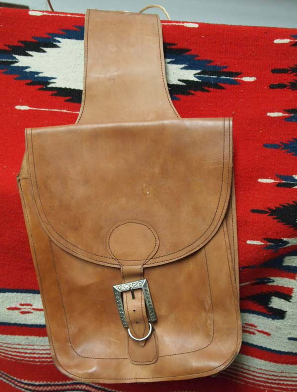 Cowboy Leather Saddlebags: DESCRIPTION: Leather saddlebags in near-new condition. Silver chased buckles are stamped ''Century'' ''Canada'' on the underside. SIZE: Measures 22'' from center rawhide lacing. Buyer pays actual ship