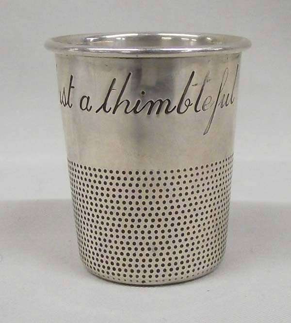 Sterling Silver ''Just a thimbleful'' Jigger: DESCRIPTION: Charming sterling silver jigger in the shape of a thimble with the words, ''Just a thimbleful'' engraved around rim. Stamped, ''STERLING'' on bottom. SIZE: Measures 2'' tall and is 1.5'' 