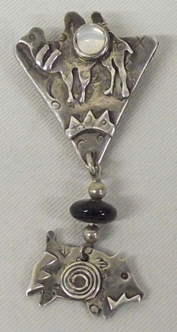 Sterling Silver Moonstone Onyx Pin by D Roberts: AGE: Contemporary DESCRIPTION: One of a kind sterling silver pin. The camel figure is set with moonstone and black onyx separates it from the pig figure. Stamped sterling and signed by artist on back,