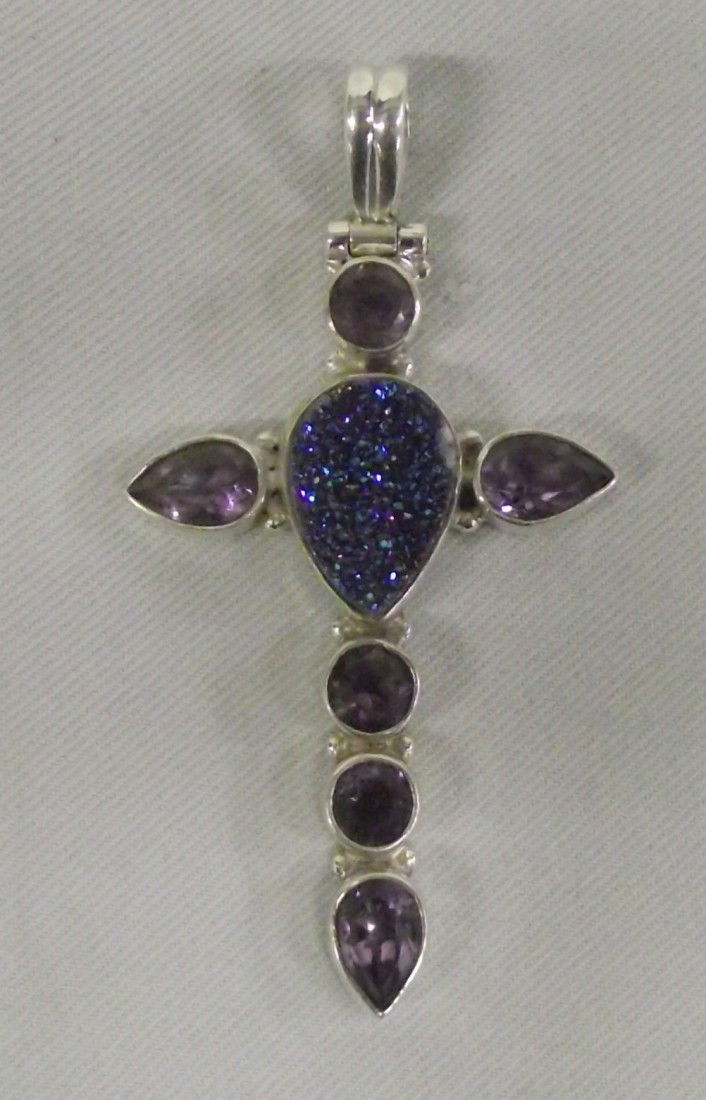 Sterling Titanium Druzy Amethyst Cross Pendant: DESCRIPTION: Blue titanium druzy center stone and 6 amethyst stones in sterling silver cross setting and bale. SIZE: Measures 2-1/8'' long x 1-1/8'' wide.