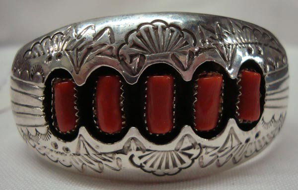 Navajo Sterling Red Coral Bracelet - P. Benally: ETHNICITY: Native American DESCRIPTION: Heavy weight holloware bracelet stamped design and shadow box setting of red coral cabochons. Stamped on the back, ''P. Benally STERLING''. SIZE: Measures 6.75'