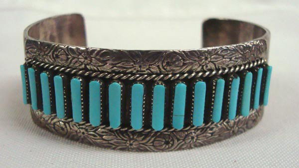 Zuni Sterling Turquoise Cuff Bracelet - Pinto: PUEBLO: Zuni ETHNICITY: Native American DESCRIPTION: Lovely light blue turquoise petit point stones surrounded by elaborate flower designs on sterling top and bottom. Hand signed A. Pinto. SIZE:6.75''