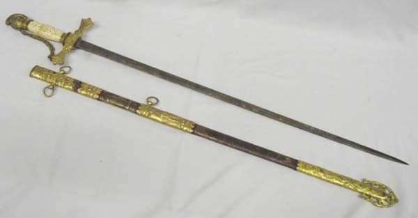 1900 Masonic Hartley & Graham Sword and Sheath: DATE: 1900's DESCRIPTION: 1900's Hartley & Graham Sword, very ornate, etched brass, scrimshaw monogrammed handle with crown above monogram and 2 olive branches around monogram, at the top of the handl