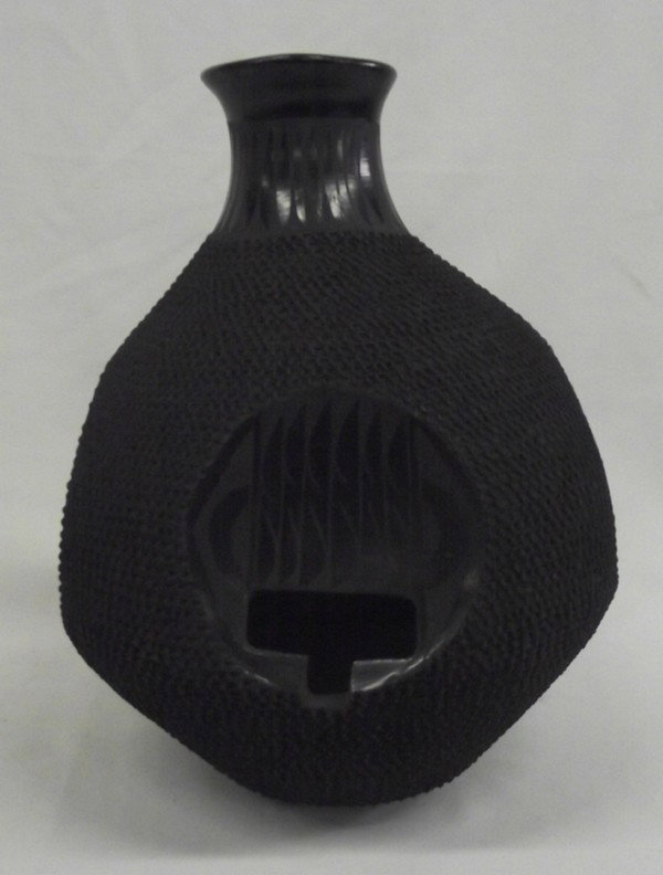Mata Ortiz Black Cutout Jar - Jose Gonzalez: Mata Ortiz Black Cutout Jar - Jose Gonzalez. Tall textured jar with four indented circles that have stylized feather designs and cutout ''T''. Signed on the bottom, ''Jose Gonzalez.'' Measures 10''Hx9
