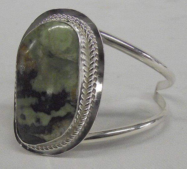 Sally Rocks Sterling Serpentine Bracelet: Sally Rocks Sterling Serpentine Grant County, New Mexico Bracelet. Beautiful serpentine polished cabochon, irregular in size and handsomely mounted on this double band bracelet. It measures 6 1/2'', i