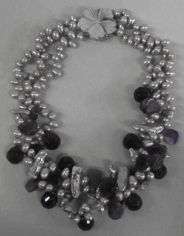 Designer Grey Pearl and Amethyst Necklace: Designer Grey Pearl and Amethyst Necklace. Three strands of hand-tied grey pearls and amethyst with a carved shell clasp, measuring 17''.