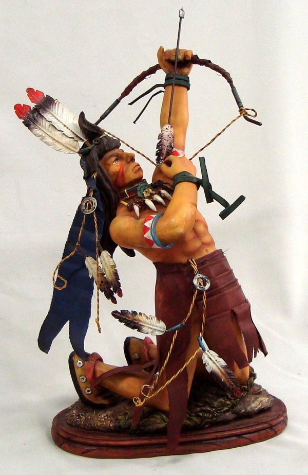 Ceramic Indian Warrior Sculpture: Ceramic Indian Warrior Sculpture. Lots of realistic trim on this warrior. Wire and metal feathers, wire bow string, fabric loin cloth, etc. Measures 15.5''H x 10''W.