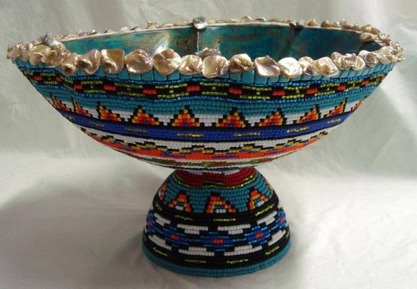 Large Hand Beaded Bowl-Kills Thunder: Large Hand Beaded Bowl-Kills Thunder. Approx 8.5''H x 14'' Diameter. Intricately beaded with bold colored beads and painted on the inside. Rim is trimmed with seashells. Heavy and beautiful.