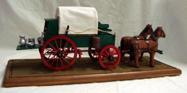 Miniature Handmade Chuck Wagon & Horses: Miniature Handmade Chuck Wagon & Horses in protective plexiglass showcase with wooden base. 18.75''H x 17.75''L X 16'' W. Wonderful wooden carved and painted horses. Clean and nice.