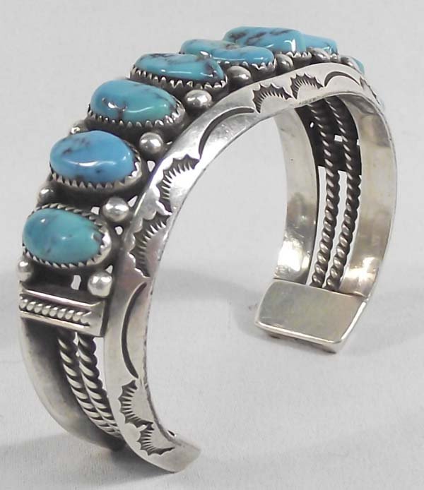 Navajo Silver Turquoise Bracelet-Wilbur Wauneka: Native American Navajo Silver Turquoise Bracelet-Wilbur Wauneka Nine turquoise cabochons decorate this hallmarked and sterling stamped bracelet 6 5/8'' wrist size by 1''H. The largest stone is 5/8''H 