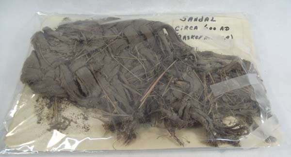 Prehistoric Basketry Sandal: Prehistoric Basketry Sandal. Contained on paper in plastic covering. Measures approx. 10''L x 5''W. Says on paper: ''Sandal circa 600AD (basket maker)''. Acquired in accordance with all state and fede