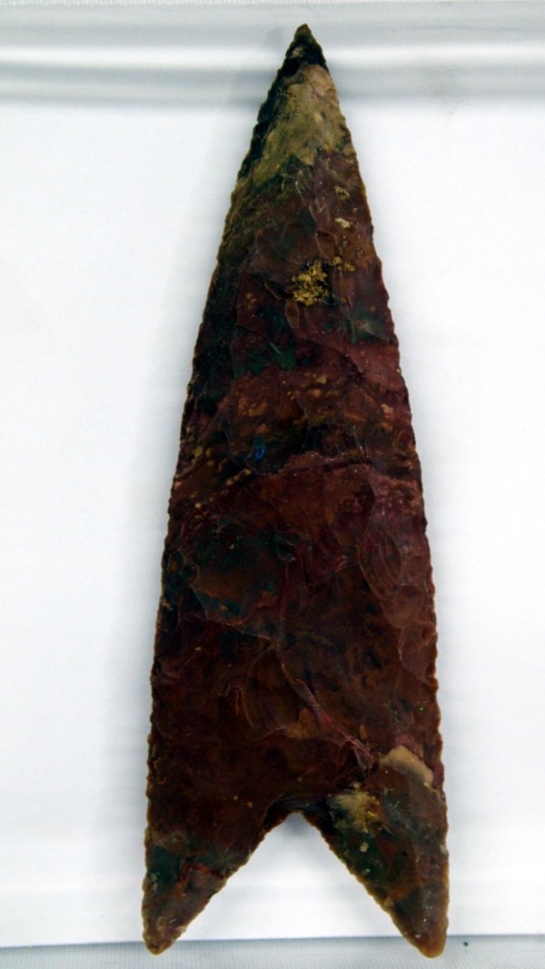 Stone Spearhead: Stone Spearhead, red and brown in color. Age and origin unknown. Measures 5 1/8'' L x 1 3/4'' W.