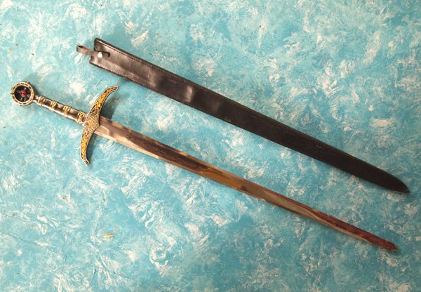 Very Large Excalibur Reproduction Sword and Case: Very Large Excalibur Reproduction Sword and Case. The round tip of the sword handle says ''Robin of Cocksley'' on one side and ''Earl of Huntington'' on the other. On both sides, the blade has the ima