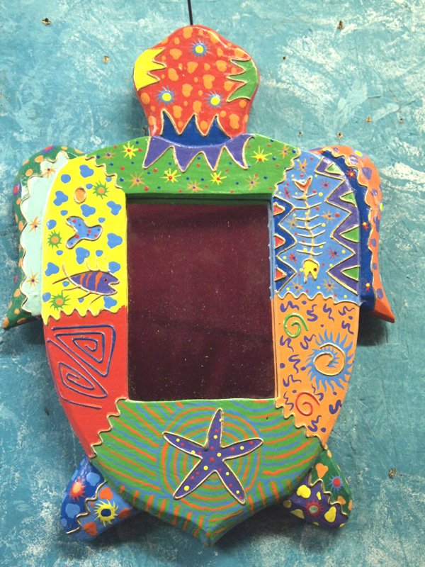 Hand Painted and Carved Turtle Mirror: Turtle mirror is a hand painted work of art. Hand painted and carved this lively piece is 13.5'' tall and 10.5'' wide. Hang in any room for a great splash of color - even in the bathroom!