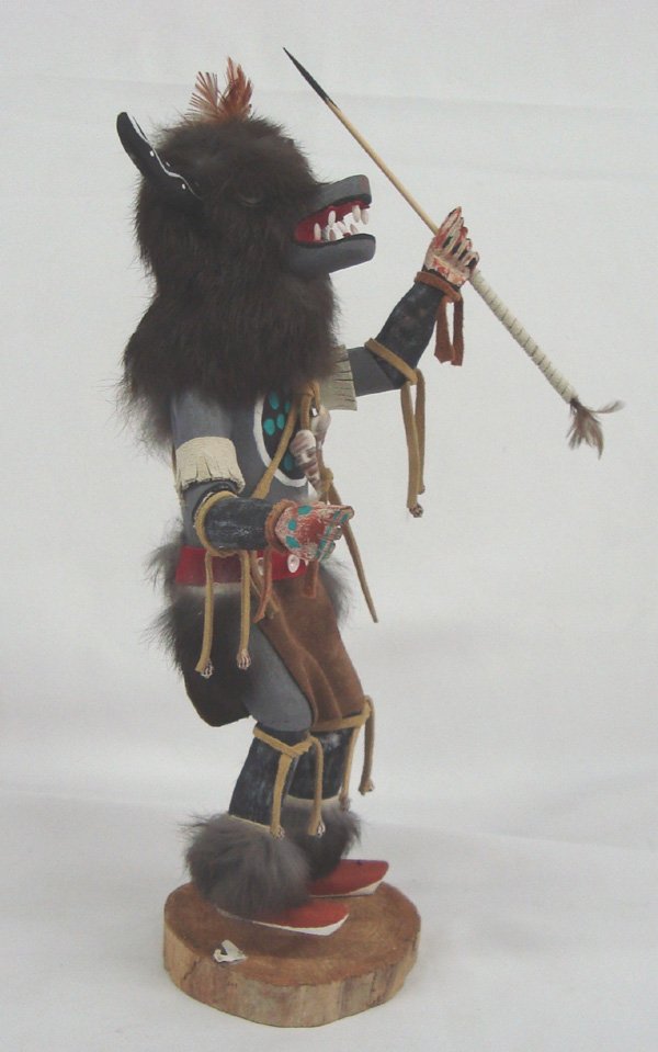 Hopi Wolf Kachina: Hopi Wolf Kachina. Wolf kachina holds a stick in his hands to represent trees and bushes that he hides behind as he watches deer and antelope. Provider of food for the tribe. 14''H x 7''W. This is a v