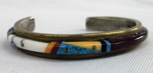 Brass Bracelet With Stone-to-Stone Inlays: Brass Bracelet With Stone-to-Stone Inlays. Bracelet measures 6 3/8'', including opening and is 3/8'' wide. The stones are turquoise, jet, shell, pink shell, sard (variety of carnelian) and lapis. It i
