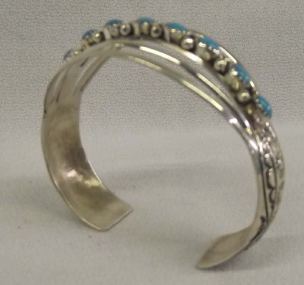 Navajo Sterling Turquoise Bracelet - W.B.: Native American Navajo Sterling Turquoise Bracelet - W.B. All sterling bracelet with 9 uniform size and color turquoise beads. Stamped design on sides of bracelet. Stamped on the inside ''Sterling WB.